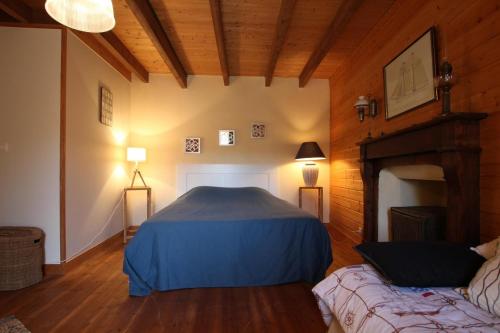 a bedroom with a blue bed in a room at gite des vieilles rues in Omonville-la-Rogue