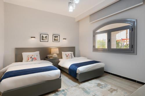 a bedroom with two beds and a window at Assiut Cement Hotel in Asyut