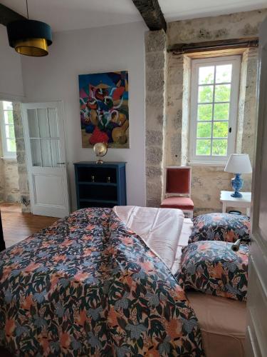 une chambre avec un lit avec une couette colorée dans l'établissement Domaine de Lagrange, à Vianne