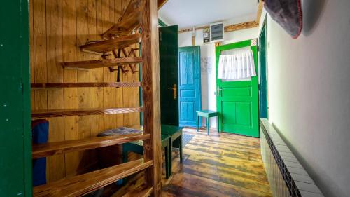 a room with green and blue doors and wooden floors at Kuća za odmor ''Julka'' in Plešce