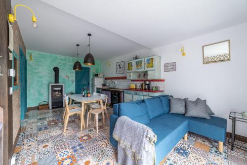 a living room with a blue couch and a kitchen at Apartamenty Lavender Hill in Wisła