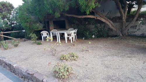 a table and chairs in front of a house at Casa Vacanze Casti - 37 in Calasetta