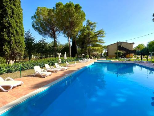 una grande piscina con sedie a sdraio e una fila di Hotel La Torretta ad Assisi