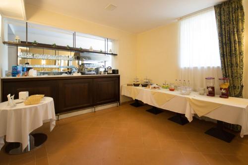 una sala da pranzo con 2 tavoli e una tovaglia bianca di Domus Stella Maris - Casa per Ferie ad Ancona