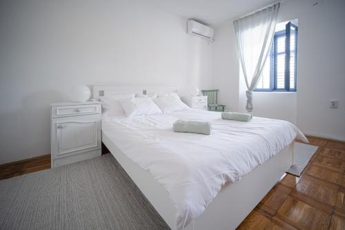 a large white bed with two pillows on it at Mediterranean House with private garden near Crikvenica in Drivenik