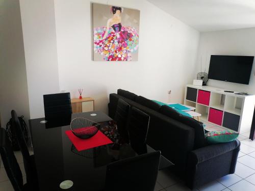 ein Wohnzimmer mit einem schwarzen Sofa und einem TV in der Unterkunft Apartman ViL in Sveti Vid-Miholjice