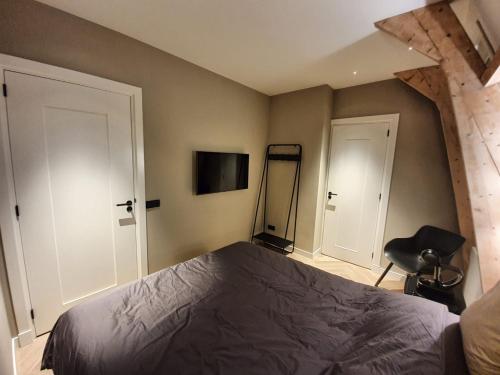 1 dormitorio con 1 cama y 1 silla en Super de luxe privékamer op een toplocatie - Room 2, en Egmond aan Zee