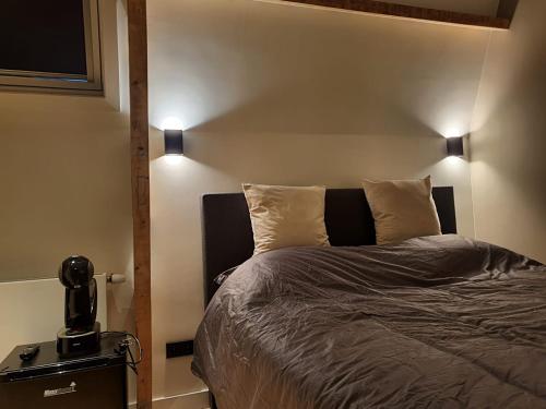 a bedroom with a bed with two lights on it at Super de luxe privékamer op een toplocatie - Room 2 in Egmond aan Zee