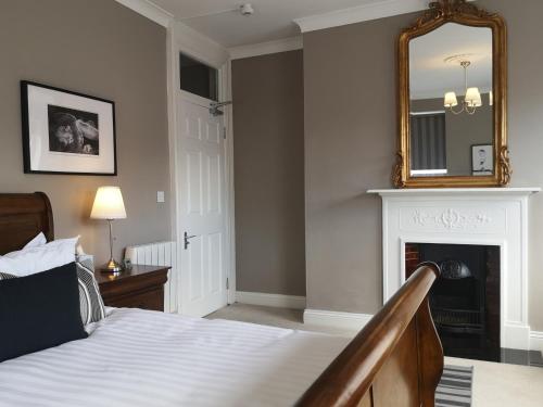a bedroom with a bed with a mirror and a fireplace at Shaw Suite in Dublin