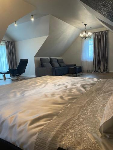 a bedroom with a large bed and a couch at Mazoji vila in Birštonas
