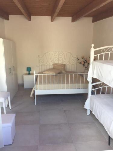 um quarto com 2 camas brancas e piso em azulejo em Casa vacanze Francesca sul mare em Mazara del Vallo