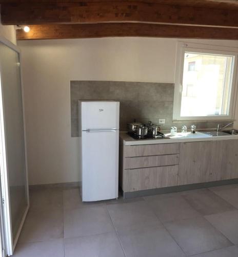 uma cozinha com um frigorífico branco e um lavatório em Casa vacanze Francesca sul mare em Mazara del Vallo