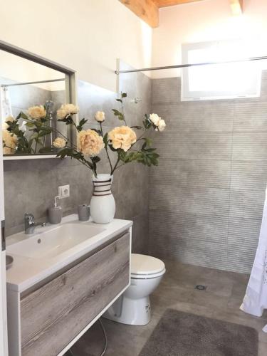 uma casa de banho com WC e um vaso com flores em Casa vacanze Francesca sul mare em Mazara del Vallo