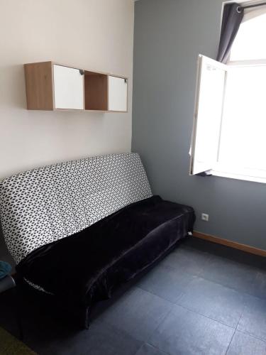 un lit dans une chambre avec une fenêtre dans l'établissement Petit studio vue mer 50m de la plage Malo, à Malo-les-Bains