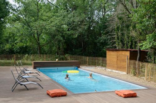 - une piscine avec 2 personnes dans l'eau dans l'établissement Petit Gîte familial au Domaine de Valmont, à Saint-Gély-du-Fesc