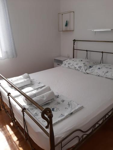 a bedroom with a bed with white sheets at Cosy, sea view apartment Porat in Porat