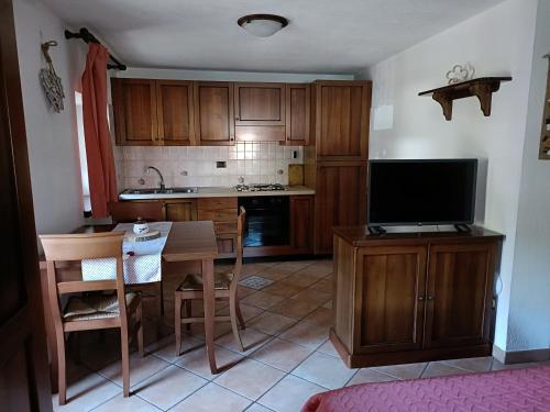 eine Küche mit einem kleinen Tisch und einem TV in der Unterkunft LO PONTON cir 0022 in Introd
