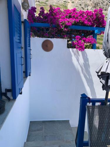 a white wall with blue doors and pink flowers at Kamara in Kamarai