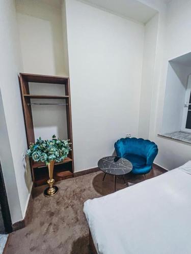 a bedroom with a blue chair and a table at Apartments Tumanyan in Yerevan