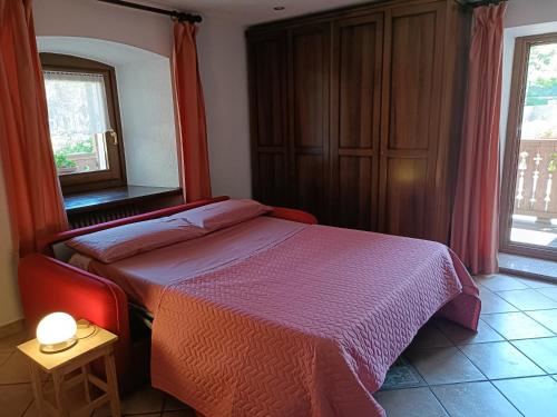 Schlafzimmer mit einem Bett, einem Spiegel und einem Fenster in der Unterkunft LO PONTON cir 0022 in Introd