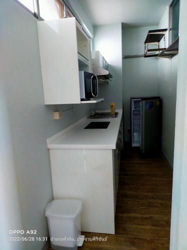 a kitchen with a white counter and a microwave at Baan Plerd Plern by Golf in Hua Hin