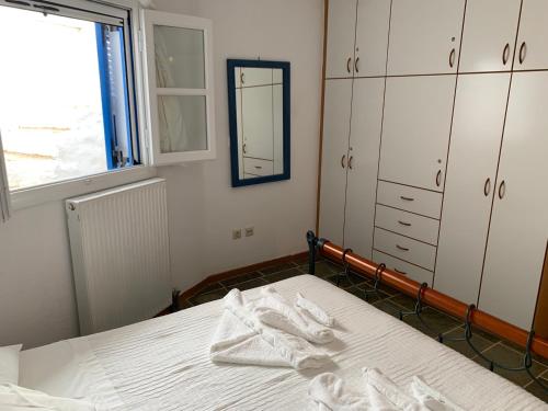 a bedroom with a bed with white sheets and a mirror at Kamara in Kamarai