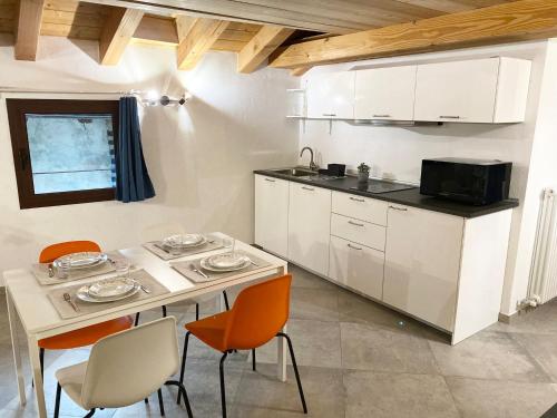 a kitchen with a table and chairs and a microwave at Chez Orsille in Aymavilles