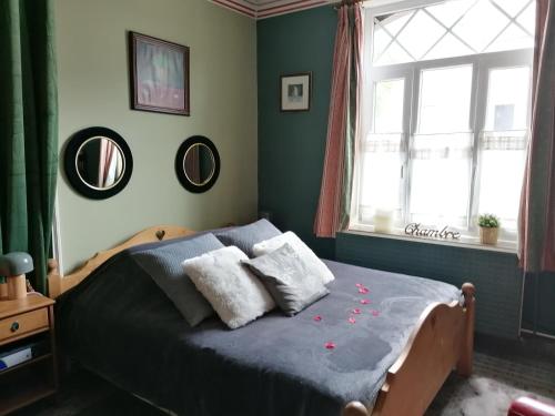 Un dormitorio con una cama con flores. en Maison d'hôte Les Notes Endormie Chambre Secrète en Berzée