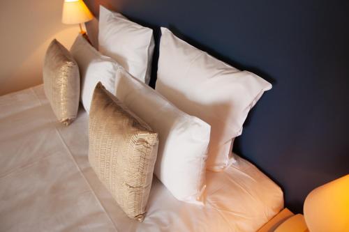 a group of pillows sitting on a bed at Hôtel des Isles in Barneville-Carteret