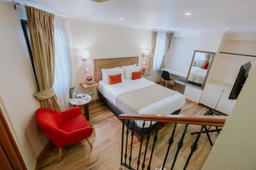a hotel room with a bed and a red chair at Tagle Hotel Boutique in Santiago