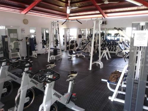 a gym with several treadmills and exercise bikes at Caribean Dreams Apartement Beautiful Pool and Gym in Santiago de los Caballeros