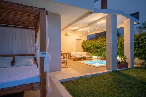 a backyard with a bed and a patio with a pool at The Whitestone in Split