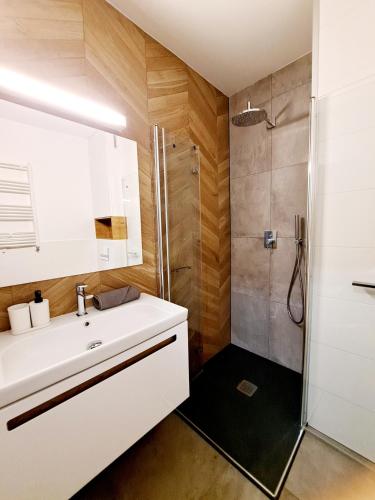 a bathroom with a white sink and a shower at Apartament Północne Mazury in Węgorzewo