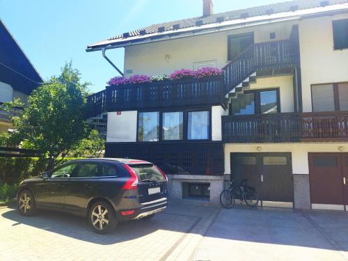a black car parked in front of a house at Apartma Vojvoda in Bohinj