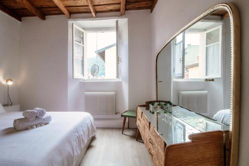 a bedroom with a mirror and a bed and a window at Silvia Como House - The House Of Travelers in Como
