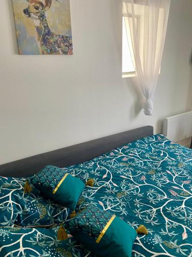 a bed with blue and white sheets and pillows at Studio ESPRIT COZY in Ballan-Miré