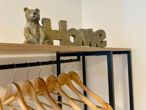 a bear statue sitting on top of a shelf with a sign at Studio ESPRIT COZY in Ballan-Miré