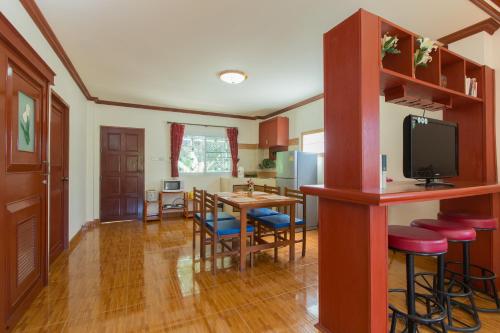 a kitchen and dining room with a table and chairs at Patong Rai Rom Yen Resort SHA in Patong Beach