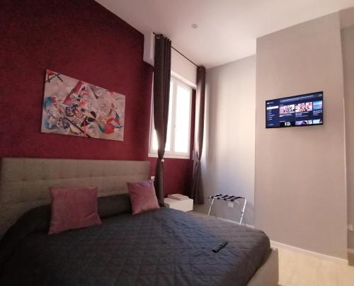 ein Schlafzimmer mit einem Bett und einem TV an der Wand in der Unterkunft Casa Beda in Bologna