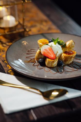 a plate of food with fruit on a table at The Imperial Dragon Hotel in Saundersfoot