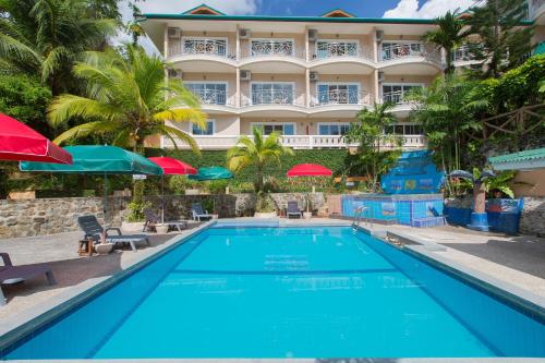 a swimming pool in front of a hotel at Patong Rai Rom Yen Resort SHA in Patong Beach