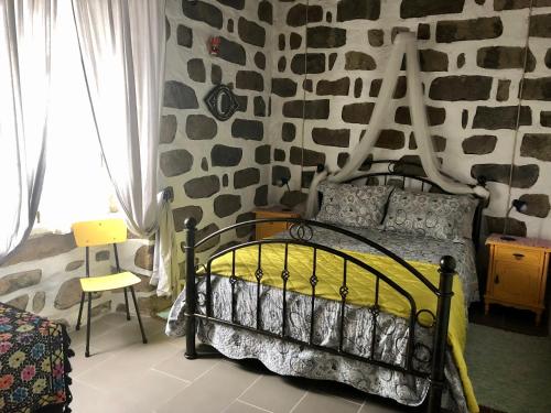 a bedroom with a bed with a rock wall at Casa Auri in Faial da Terra