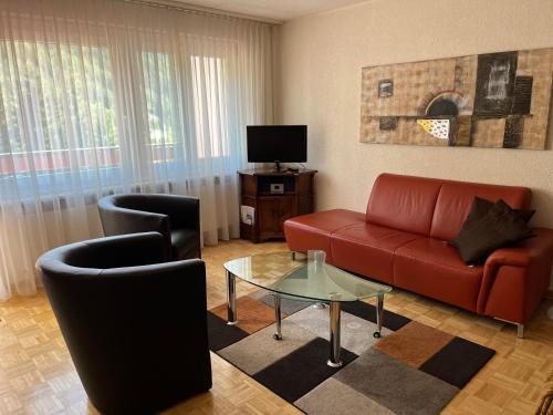 a living room with a red couch and two chairs at Residenz Majesta in Leukerbad