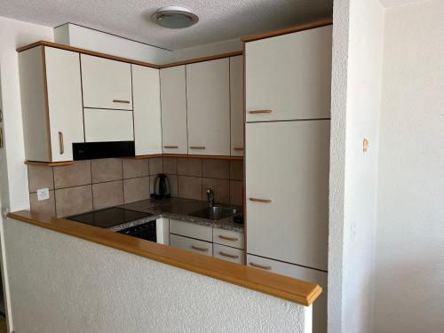 a kitchen with white cabinets and a sink at Residenz Majesta in Leukerbad