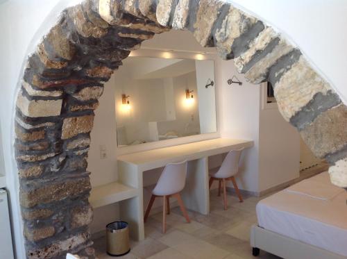 a room with a mirror and a table and chairs at Hotel Anixis in Naxos Chora