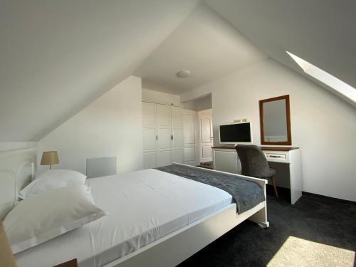 Villa Aqua Family Hotel في مدينة بورغاس: غرفة نوم بيضاء مع سرير ومكتب