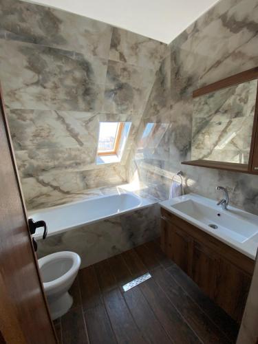 uma casa de banho com uma banheira, um lavatório e um WC. em Villa Aqua Family Hotel em Burgas