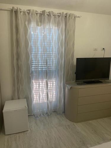 a living room with a television and a window at La perla del mare in La Caletta