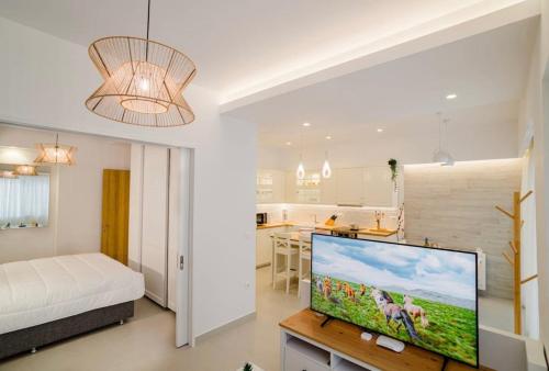 a living room with a television and a kitchen at Old town luxury apartment in Kos