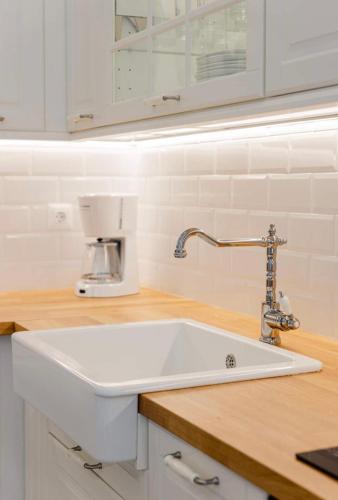 a white sink in a kitchen with a counter at Old town luxury apartment in Kos